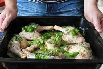raw chicken legs with basil and spices ready to roast