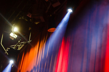 Stage light with colored spotlight. Red curtain and smoke effect