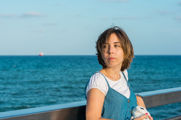 Young woman with a instant camera in the coast