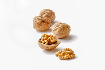 group of cracked walnuts cloth on a white backdrop in a soft backlight