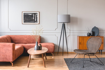 Stylish tall grey lamp in elegant living room interior with comfortable brown corner sofa