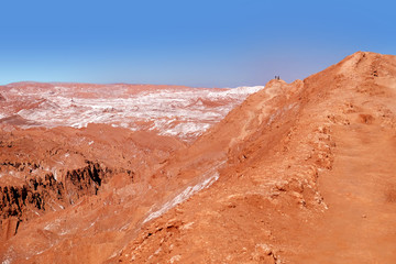 Desert landscape of the Moon Valley near San Pedro de Atacama, in the northern part of Chile, against a blue sky covered by clouds.