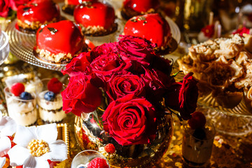 Bouquet off red roses and red berry cupcakes. St. Valentine's Day, Mother's Day, Birthday, Wedding banquet