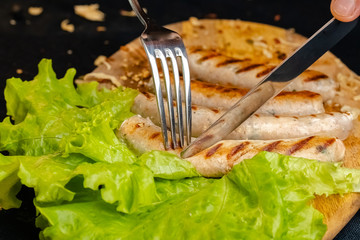 homemade hotdog sausages fried from red and white fish meat, in a vintage rustic plate bowl, fork...