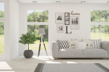Stylish room in white color with sofa and summer landscape in window. Scandinavian interior design. 3D illustration