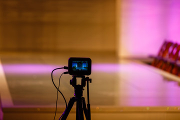 Camera viewfinder in front of empty stage, camera ready for recording. Backstage of recording or...