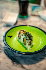 Small sushi on green plate at chinese restaurant