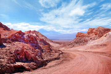 Desert landscape of the Moon Valley near San Pedro de Atacama, in the northern part of Chile, against a blue sky covered by clouds.