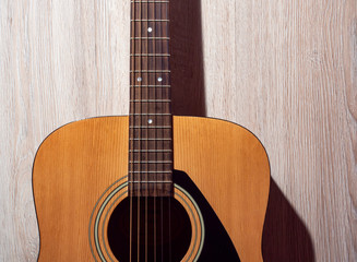 Obraz premium Classical acoustic guitar brown on light wooden background