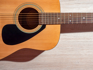 Obraz premium Classical acoustic guitar brown on light wooden background