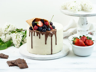 Laminated cake with white cream and fruit, poured on top with chocolate