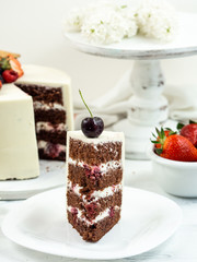Laminated cake with white cream and fruit, poured on top with chocolate