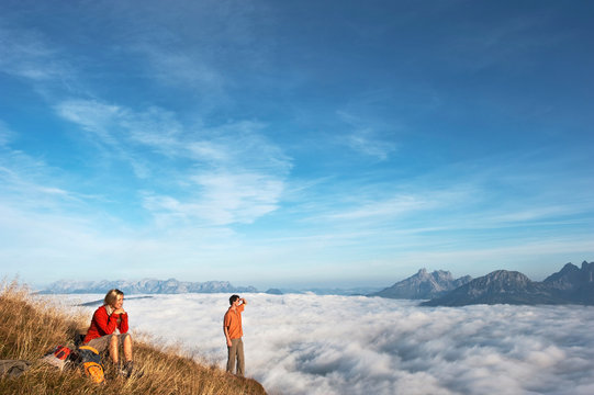 Austria, Steiermark, Reiteralm, Hikers admiring view over clouds