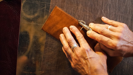 Small business concept. Chamfering with leather billet by tanner.