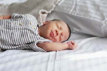 cute newborn baby in bed at home