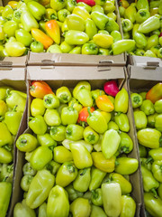 Ripe yellow-green peppers in the market. Autumn harvest concept, organic food, fruits. An abundance of fruit.