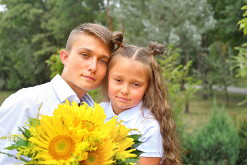 a bouquet for first beloved teacher on first of September. Flowers for the last bell. day of knowledge. beginning of the school year. first-grader with bouquet in a school uniform