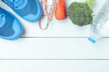Healthy concept, Diet and fitness ,sport shoes,broccoli, bottle of water on white wooden background.