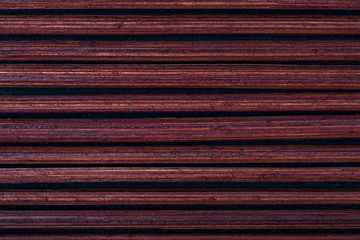 Dark reddish bamboo texture (collection of vegetal and natural fibers). Foreground.