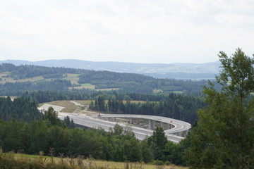 construction of a modern overpass in mountains, high-speed concrete road in a mountainous area, a...