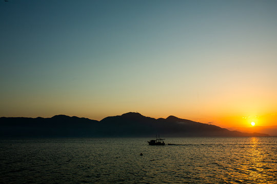 Barco no mar,  barco no por do sol, barco na praia, por do sol