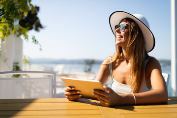 Beautiful woman selecting summer sea destination for holiday vacation - Powered by Adobe