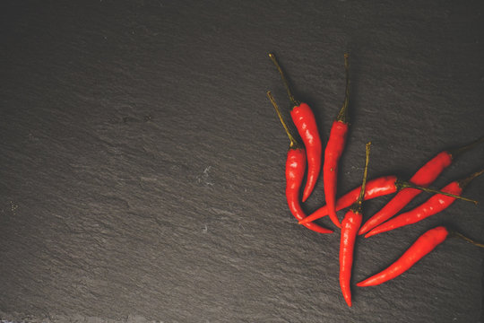 Chillies on slate, stone grunge texture. Vintage tone. Food Copy Space