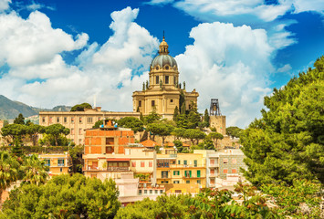 Fototapeta na wymiar Cityscape of Messina with Cathedral on the top of the hill, colored houses and beautiful clouds with a blue sky, Sicily, Italy