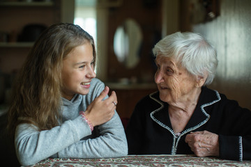 Nice teen girl with her old grandmother.