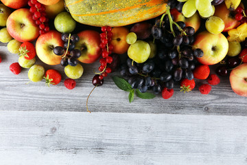 Tropical fruits background, many colorful ripe fruits with strawberries, grapes and cherries on...