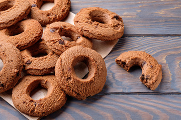 Sweet delicious ring-shaped chocolate chip cookies on a wooden table