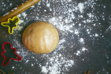 Female hands in flour making Christmas cookie in the form of gingerbread man from dough in kitchen. Home baking process