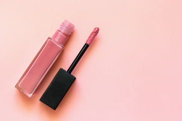 Lipstick and applicator wand on pastel pink backgrpund. Liquid lip stick open tube. Makeup cosmetic...