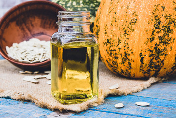 Closeup of a bottle of pumpkin seed essential oil on a napkin with burlap.
