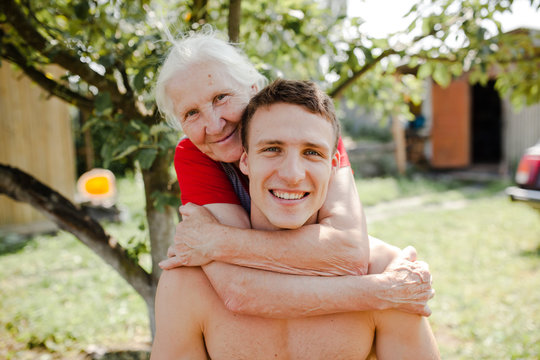 Happy grandmother embracing grown up man