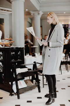 Woman reading newspaper in cozy reception