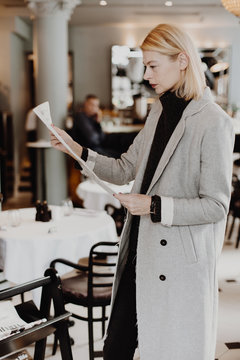 Woman reading newspaper in cozy reception