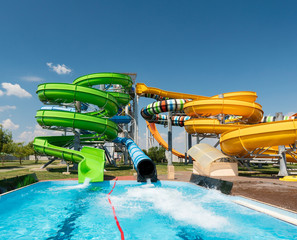 Water park, bright multi-colored slides with a pool. A water park without people on a summer day...