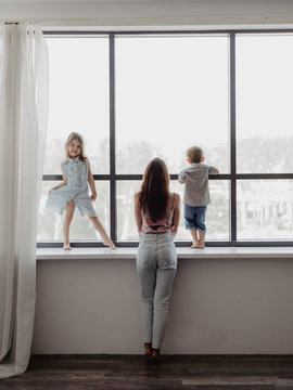 Mother and children looking out window