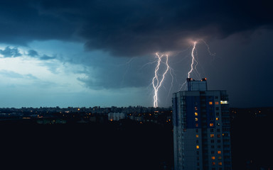 Lightning in stormy sky above dark city