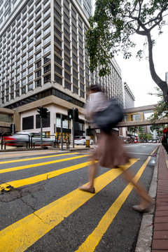 Young beautiful woman in beige coat with a bag crossing the street-upper view