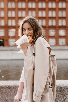 Woman eating pastry near river