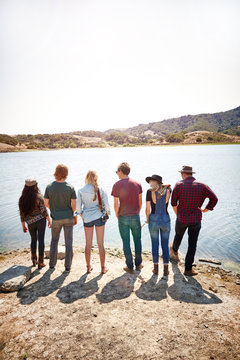 Group of millennial friends at a lake looking at view