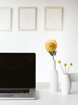 Laptop and flowers on table