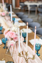 Candles in the foreground. Luxury dinner Banquet in the restaurant. Beautiful and exquisite decoration of the wedding celebration.