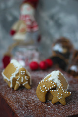 Traditional homemade gingerbread cookies on red rustic background with imitation snow,close up,Christmas concept,gingerbread house and gingerbread man