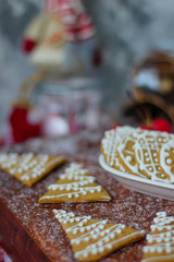 Obraz na płótnie Canvas Traditional homemade gingerbread cookies on red rustic background with imitation snow,close up,Christmas concept,gingerbread house and gingerbread man