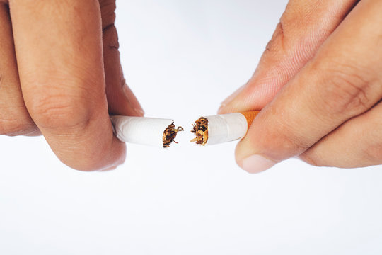 Man holding broken cigarette in front. Isolated on white background.