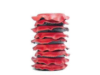 Column of isolated circular magnets lined in red and black leather arranged vertically with white...