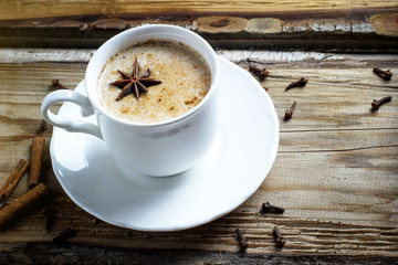 Indian masala chai tea. Spiced tea with milk on dark wooden table. Selective focus, horizontal with copy space.Sunlight.